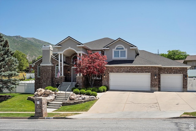 5040 S 1450 E, Ogden, UT 84403 - traditional-style home with driveway, stucco siding, an attached garage, roof with shingles, and a mountain view