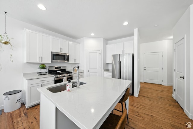 15104 S Halter Way, Bluffdale, UT 84065 - kitchen featuring stainless steel appliances, wood finished floors, a kitchen island with sink, white cabinetry, and recessed lighting