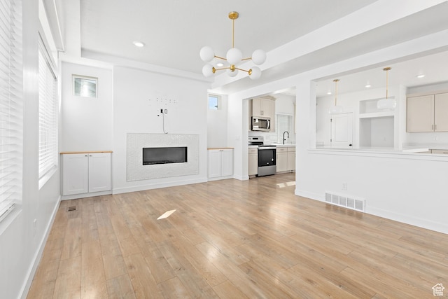 4397 W Bromwell Ct, Lehi, UT 84043 - unfurnished living room with a chandelier, a fireplace, light wood-type flooring, and recessed lighting