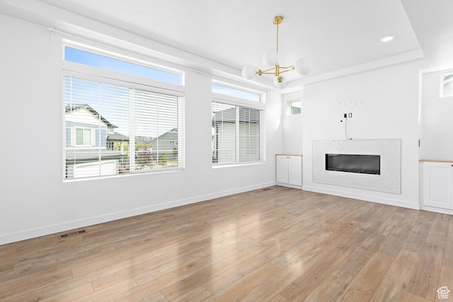 4397 W Bromwell Ct, Lehi, UT 84043 - unfurnished living room with a chandelier, a glass covered fireplace, light wood-style flooring, and recessed lighting