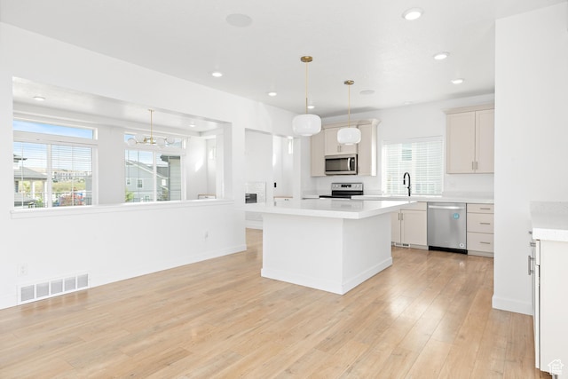 4397 W Bromwell Ct, Lehi, UT 84043 - kitchen with appliances with stainless steel finishes, light countertops, light wood finished floors, a kitchen island, and recessed lighting