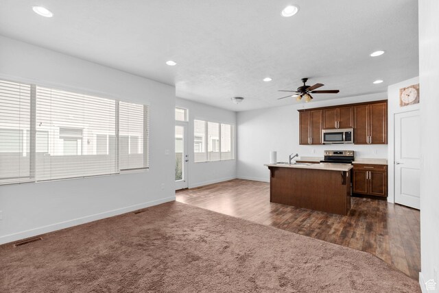 15218 S Tack Way, Bluffdale, UT 84065 - kitchen with stainless steel appliances, recessed lighting, dark colored carpet, a ceiling fan, and open floor plan