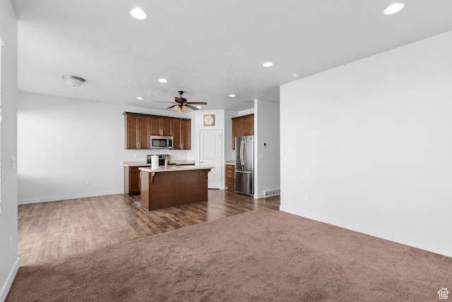 15218 S Tack Way, Bluffdale, UT 84065 - kitchen with appliances with stainless steel finishes, open floor plan, recessed lighting, an island with sink, and light countertops