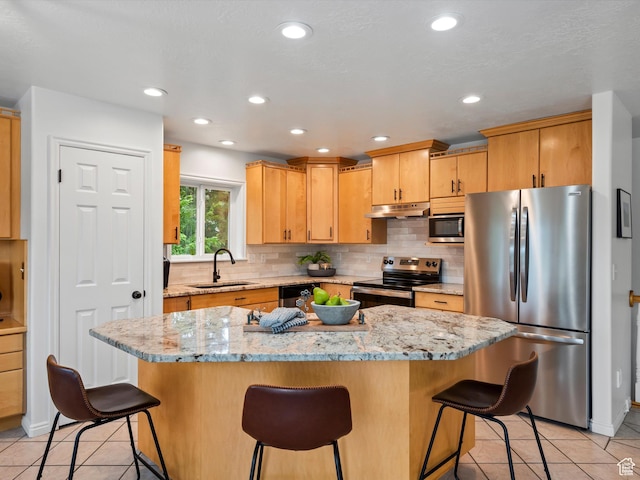 4829 E Patio Springs Cir N, Eden, UT 84310 - kitchen featuring stainless steel appliances, under cabinet range hood, light tile patterned floors, a kitchen island, and recessed lighting