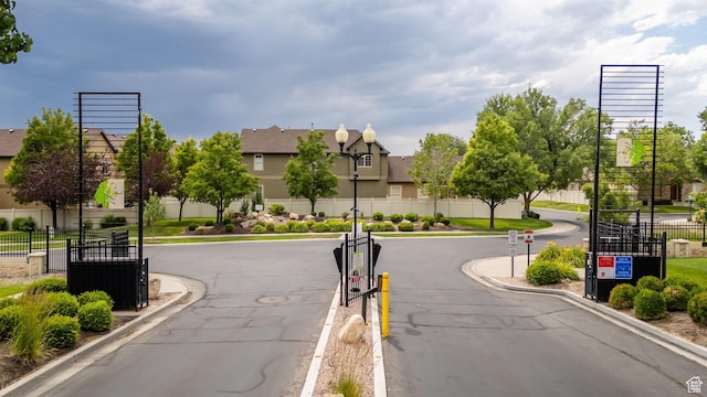 602 E Wyngate Pointe Ln S, Draper, UT 84020 - view of asphalt street with street lights, curbs, a gated entry, a residential view, and traffic signs