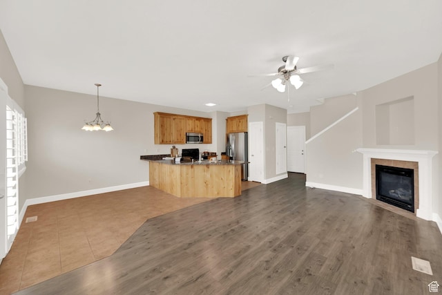 602 E Wyngate Pointe Ln S, Draper, UT 84020 - unfurnished living room featuring ceiling fan, a chandelier, a tile fireplace, and dark wood-style flooring