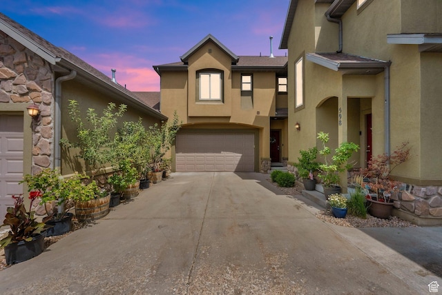 602 E Wyngate Pointe Ln S, Draper, UT 84020 - view of property featuring stucco siding, driveway, an attached garage, and stone siding