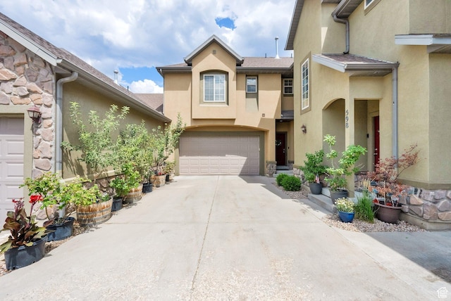 602 E Wyngate Pointe Ln S, Draper, UT 84020 - view of property with stucco siding, driveway, an attached garage, and stone siding