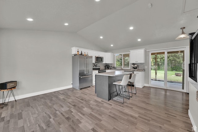 6337 S Coybrook Dr, Taylorsville, UT 84129 - kitchen with stainless steel appliances, a kitchen bar, white cabinets, vaulted ceiling, and tasteful backsplash