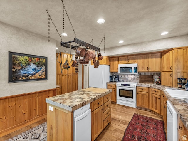 8998 Timphaven Rd, Sundance, UT 84604 - kitchen with white appliances, light wood-type flooring, decorative backsplash, wainscoting, and a kitchen island