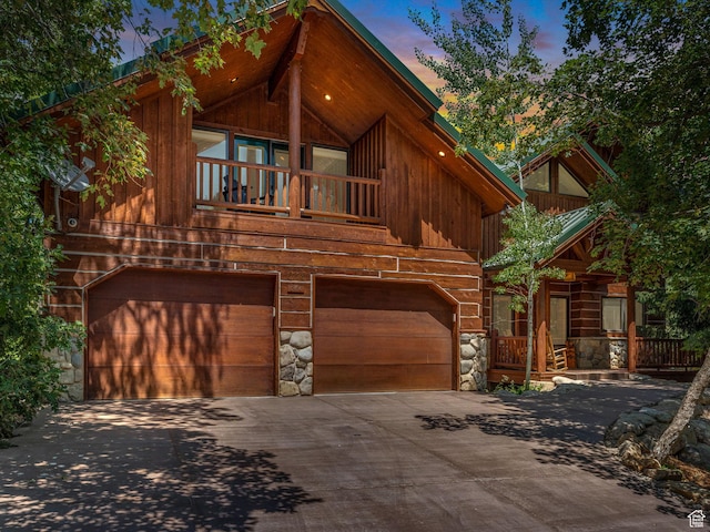 8998 Timphaven Rd, Sundance, UT 84604 - chalet / cabin featuring stone siding, concrete driveway, a garage, and a balcony