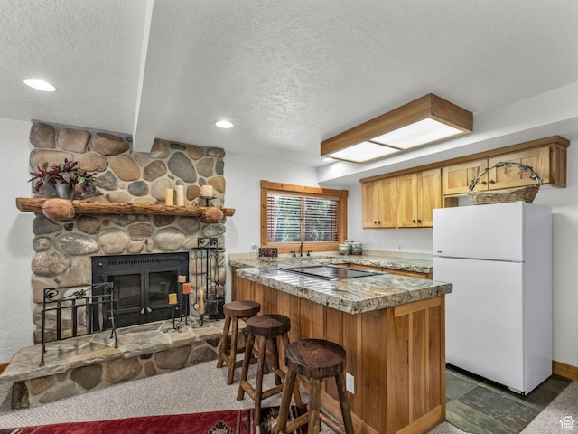 8998 Timphaven Rd, Sundance, UT 84604 - kitchen with freestanding refrigerator, a textured ceiling, a peninsula, a breakfast bar area, and black electric stovetop