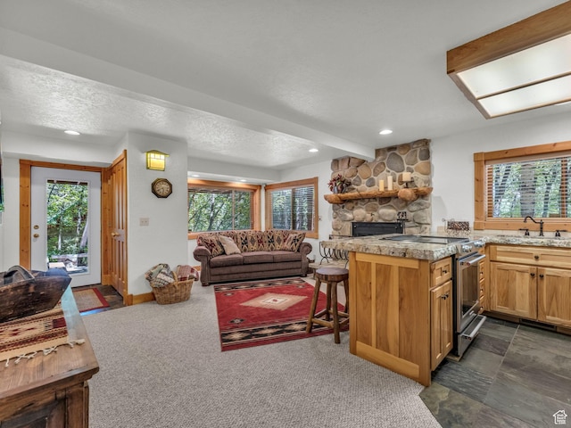 8998 Timphaven Rd, Sundance, UT 84604 - kitchen featuring electric range, a stone fireplace, plenty of natural light, open floor plan, and recessed lighting