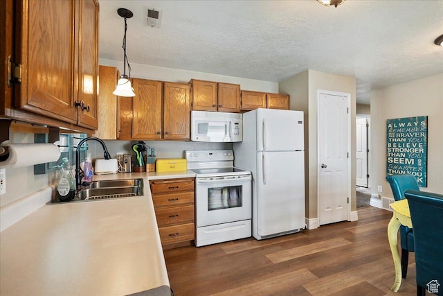 3042 S Festival Dr W, West Valley City, UT 84120 - kitchen with white appliances, brown cabinets, light countertops, dark wood-style flooring, and hanging light fixtures