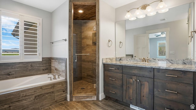 536 E Fiona Cir, Grantsville, UT 84029 - full bathroom featuring wood finished floors, vanity, a bath, a stall shower, and a ceiling fan