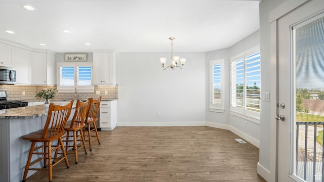 536 E Fiona Cir, Grantsville, UT 84029 - kitchen with range with gas cooktop, stainless steel microwave, wood finished floors, backsplash, and recessed lighting