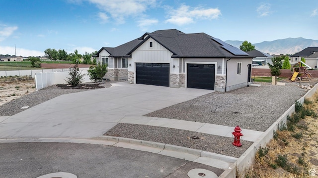 536 E Fiona Cir, Grantsville, UT 84029 - view of front facade with an attached garage, concrete driveway, board and batten siding, roof with shingles, and solar panels