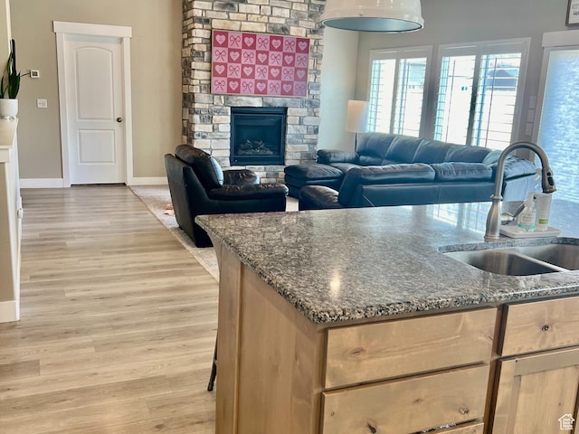 1048 N 200 E, Nephi, UT 84648 - kitchen featuring light wood finished floors, dark stone countertops, a stone fireplace, and open floor plan