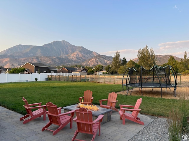 1048 N 200 E, Nephi, UT 84648 - fenced backyard featuring a trampoline, a fire pit, a patio, and a mountain view