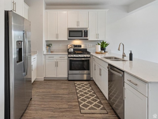 1011 W Lapis Fields Way S, Bluffdale, UT 84065 - kitchen with stainless steel appliances, a peninsula, dark wood-style floors, white cabinetry, and light stone counters