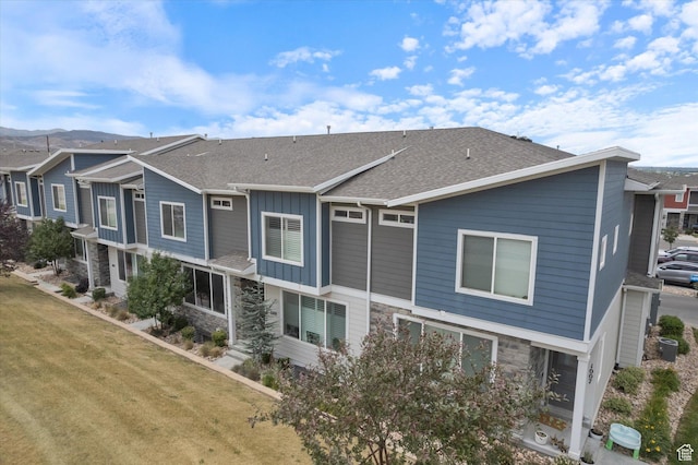 1011 W Lapis Fields Way S, Bluffdale, UT 84065 - rear view of property featuring stone siding, a shingled roof, board and batten siding, and a lawn
