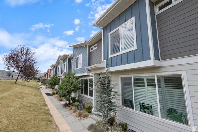 1011 W Lapis Fields Way S, Bluffdale, UT 84065 - view of side of property featuring board and batten siding, a lawn, a residential view, and stone siding