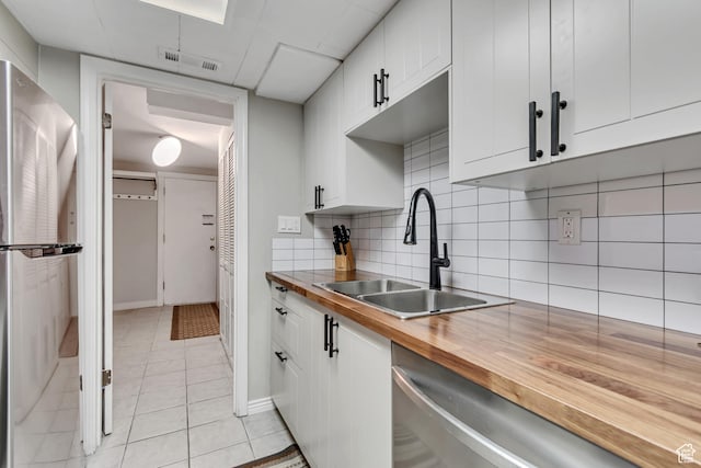5398 S Tonalea Dr, Salt Lake City, UT 84107 - kitchen with appliances with stainless steel finishes, light tile patterned floors, wood counters, white cabinetry, and tasteful backsplash