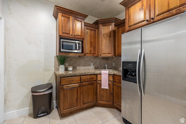 480 W Tonapah Way, Ivins, UT 84738 - kitchen with appliances with stainless steel finishes, backsplash, light stone countertops, brown cabinets, and light tile patterned flooring