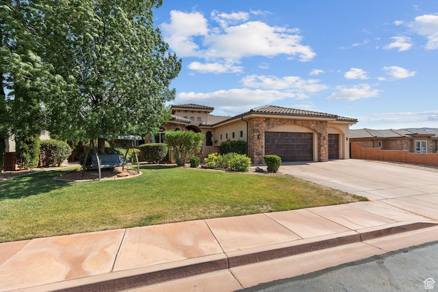 480 W Tonapah Way, Ivins, UT 84738 - mediterranean / spanish home with an attached garage, concrete driveway, stone siding, a front yard, and a tiled roof