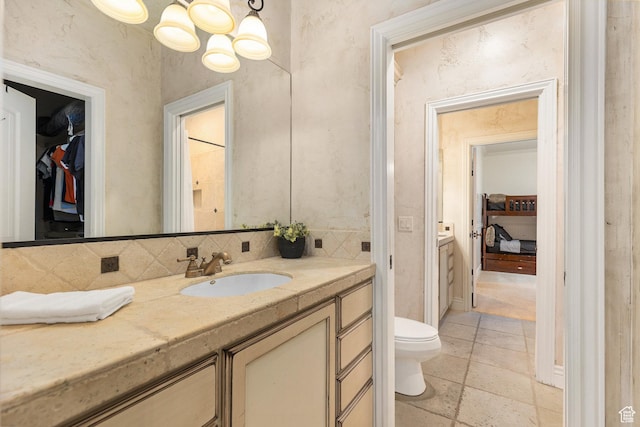 480 W Tonapah Way, Ivins, UT 84738 - bathroom with decorative backsplash, vanity, a chandelier, a walk in closet, and stone tile floors