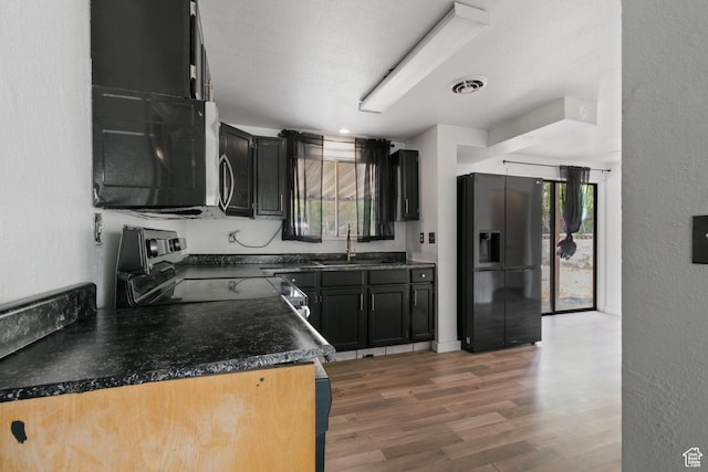3310 S 3200 W, West Valley City, UT 84119 - kitchen featuring black fridge with ice dispenser, electric stove, light wood-style flooring, dark countertops, and dark cabinets