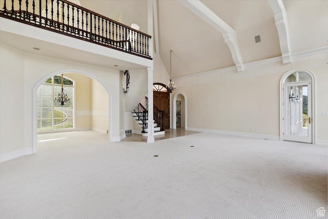3356 Twin Peaks Cir, Layton, UT 84040 - unfurnished living room featuring arched walkways, carpet, a towering ceiling, and stairway