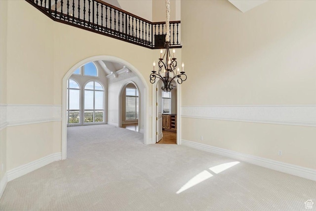 3356 Twin Peaks Cir, Layton, UT 84040 - carpeted empty room featuring arched walkways, a chandelier, and a high ceiling