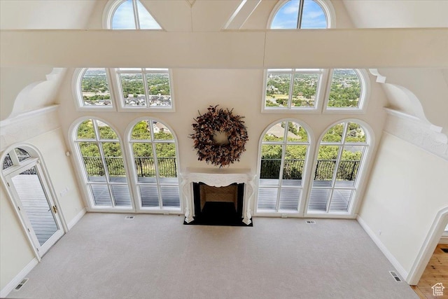 3356 Twin Peaks Cir, Layton, UT 84040 - unfurnished living room featuring a high ceiling, carpet flooring, plenty of natural light, and a fireplace with flush hearth