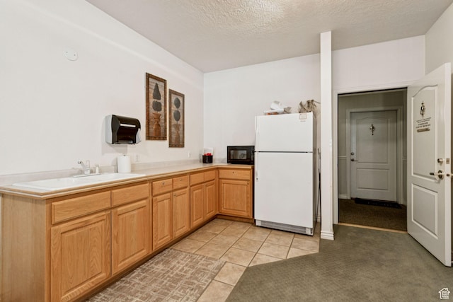 838 E S Temple S Unit 409, Salt Lake City, UT 84102 - kitchen with freestanding refrigerator, black microwave, light tile patterned flooring, a textured ceiling, and light countertops