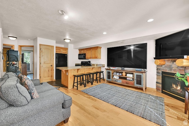 5060 E Lakeview Dr Unit 1109, Eden, UT 84310 - living area featuring a fireplace, a textured ceiling, light wood-style floors, and recessed lighting