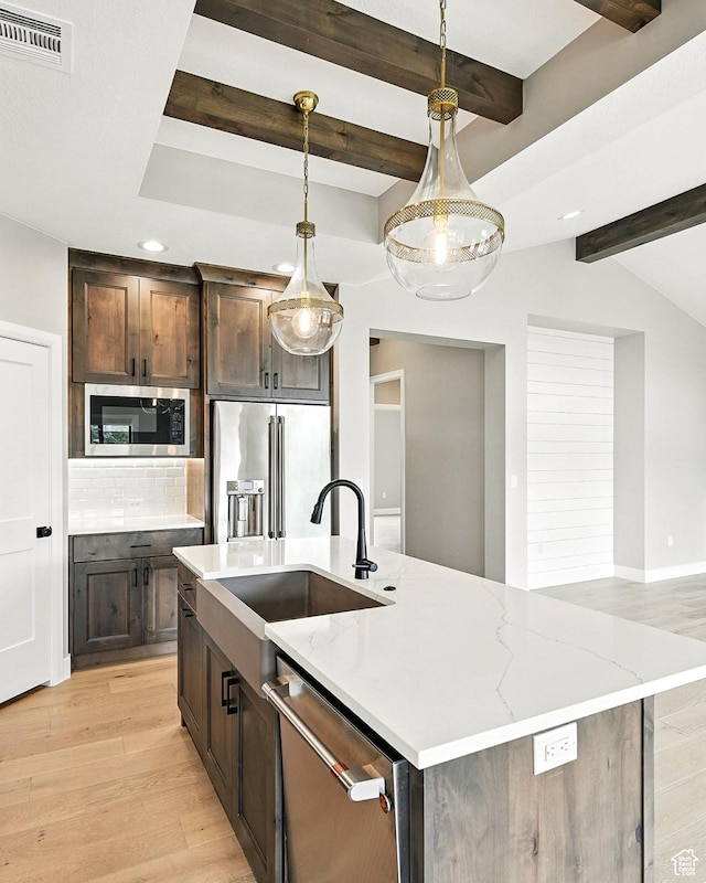 3127 W 2350 S, Cedar City, UT 84720 - kitchen with stainless steel appliances, an island with sink, light wood finished floors, tasteful backsplash, and beam ceiling