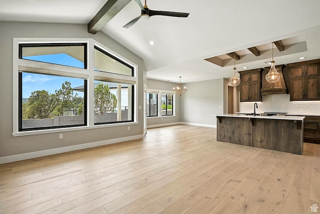 3127 W 2350 S, Cedar City, UT 84720 - kitchen with custom range hood, open floor plan, dark brown cabinets, light countertops, and decorative backsplash