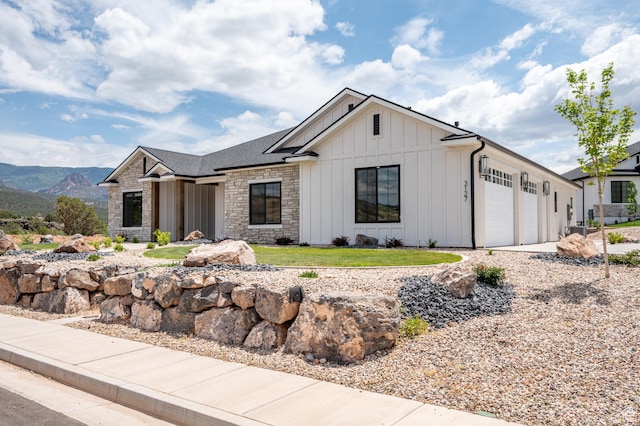3127 W 2350 S, Cedar City, UT 84720 - view of front of house with board and batten siding, a garage, and stone siding