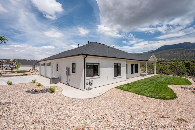 3127 W 2350 S, Cedar City, UT 84720 - rear view of property with concrete driveway, a shingled roof, stucco siding, a mountain view, and an attached garage