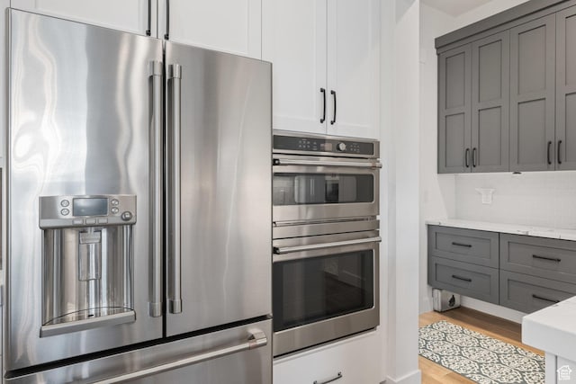 2616 S 3210 E, St George, UT 84790 - kitchen featuring stainless steel appliances, gray cabinetry, light wood finished floors, and light stone countertops