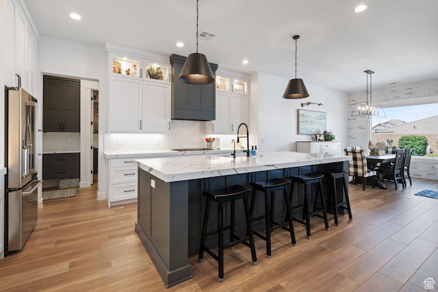 2616 S 3210 E, St George, UT 84790 - kitchen featuring high quality fridge, light wood-type flooring, backsplash, light stone countertops, and recessed lighting