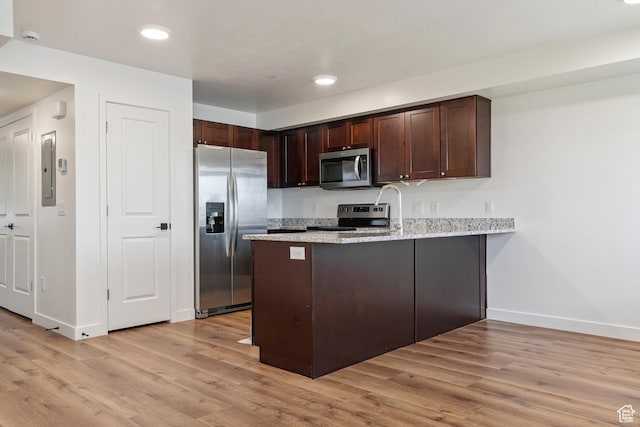456 W Main N, Santaquin, UT 84655 - kitchen with appliances with stainless steel finishes, a peninsula, light wood-type flooring, dark brown cabinets, and light stone countertops