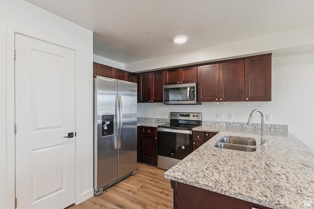456 W Main N, Santaquin, UT 84655 - kitchen featuring stainless steel appliances, light wood-type flooring, light stone counters, a peninsula, and dark brown cabinets