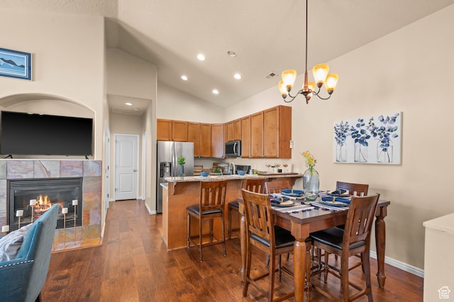 6391 W Passenger Ct S, West Jordan, UT 84081 - dining room with a chandelier, dark wood-type flooring, recessed lighting, high vaulted ceiling, and a fireplace