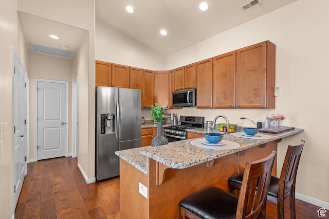 6391 W Passenger Ct S, West Jordan, UT 84081 - kitchen featuring stainless steel appliances, brown cabinets, light stone counters, recessed lighting, and lofted ceiling