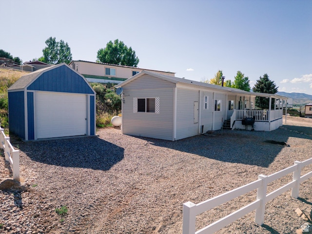 738 E Vanessa Ln Unit 386, Garden City, UT 84028 - view of front of house with an outdoor structure, a detached garage, a porch, and driveway