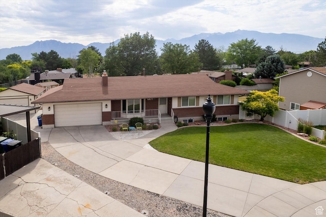 6871 S Alfalfa Cir, West Jordan, UT 84084 - single story home with covered porch, concrete driveway, a mountain view, an attached garage, and brick siding