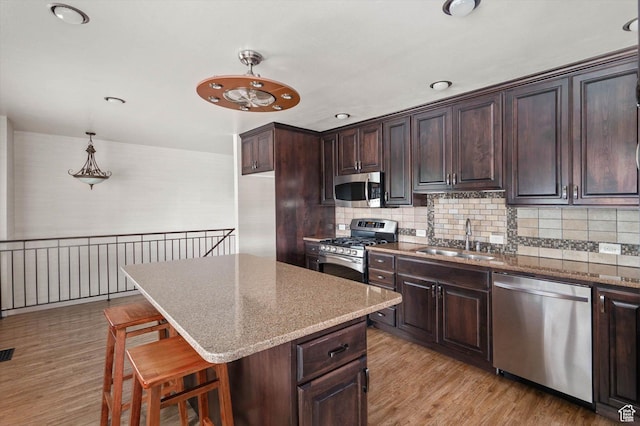 6871 S Alfalfa Cir, West Jordan, UT 84084 - kitchen featuring appliances with stainless steel finishes, dark brown cabinetry, light wood finished floors, tasteful backsplash, and recessed lighting