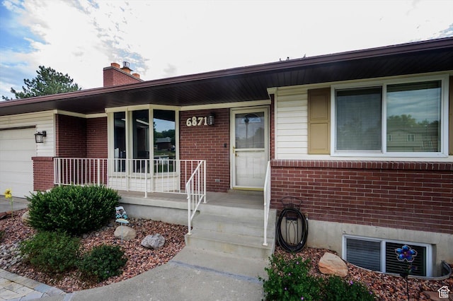 6871 S Alfalfa Cir, West Jordan, UT 84084 - entrance to property with covered porch, brick siding, a garage, and a chimney